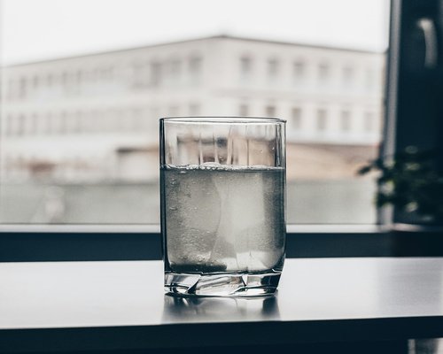 Glass of water on a table representing daily hydration habit
